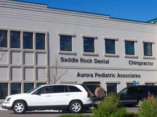 Saddle Rock Dental office building exterior in Centennial with parked vehicles and signage.