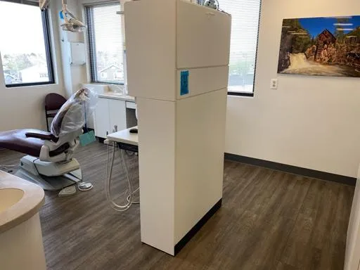 Modern dental office interior with treatment chair, equipment, and neutral décor at Saddle Rock Dental.